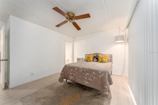 bedroom with ceiling fan, a textured ceiling, and light wood-type flooring