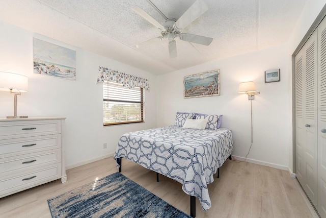 bedroom featuring ceiling fan, a textured ceiling, light wood-type flooring, and a closet