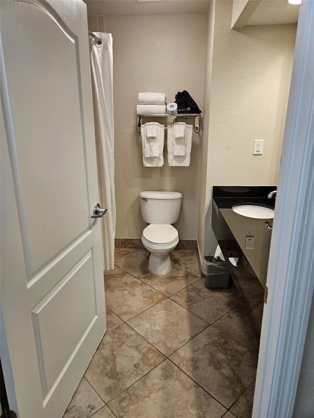 bathroom featuring vanity, tile floors, and toilet