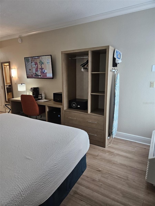 bedroom featuring light hardwood / wood-style floors, a closet, and crown molding