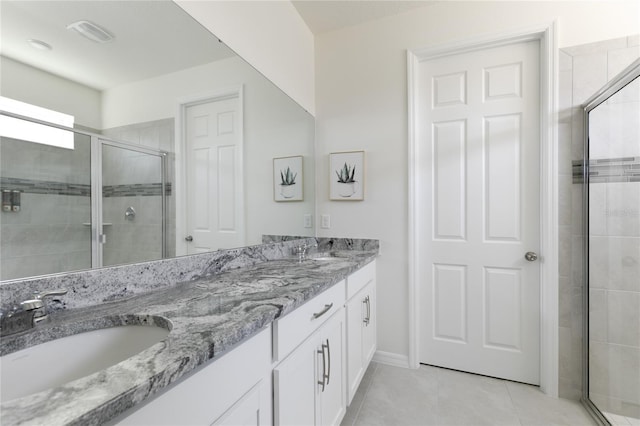 bathroom featuring tile patterned flooring, vanity, and a shower with door