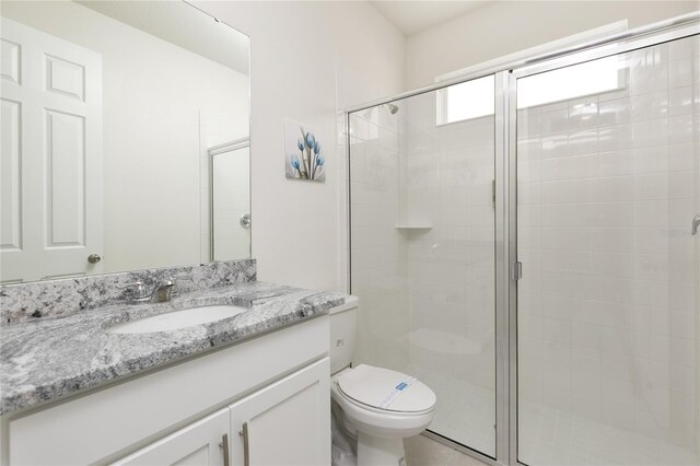 bathroom featuring vanity, an enclosed shower, and toilet