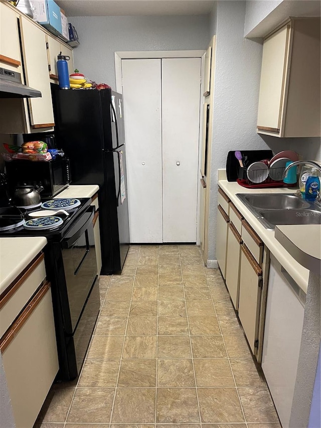 kitchen featuring sink, white cabinets, black appliances, and light tile patterned floors