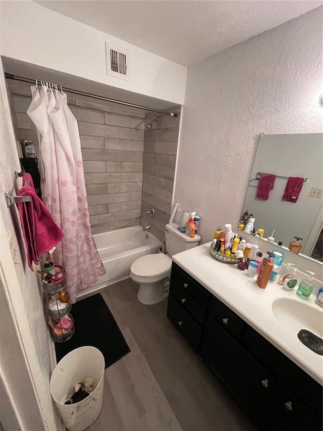 full bathroom featuring shower / bathtub combination with curtain, a textured ceiling, toilet, vanity, and wood-type flooring