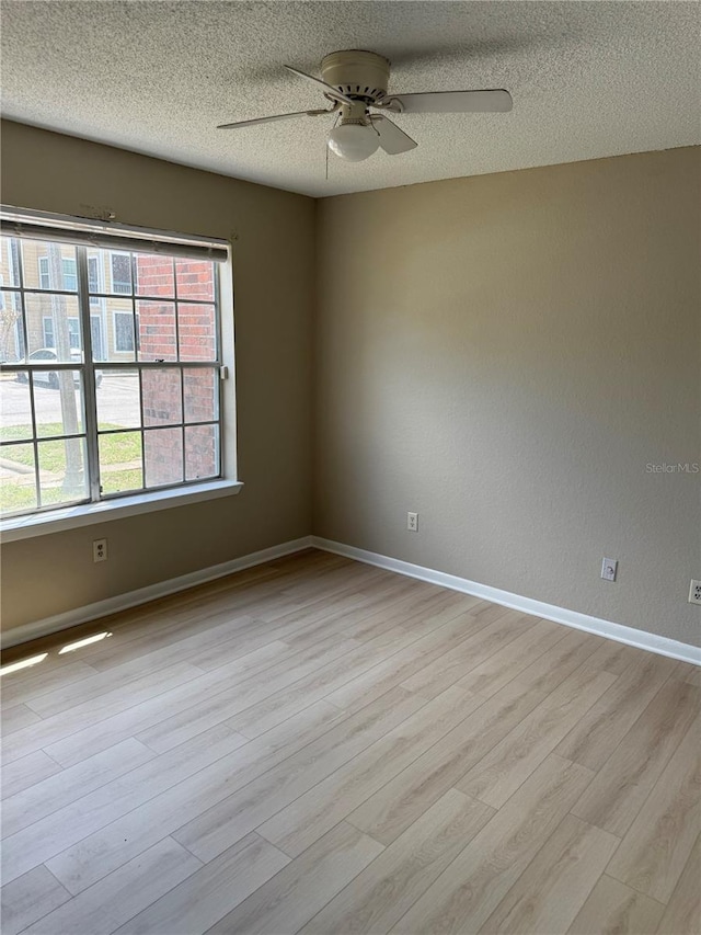 5635 Devonbriar Way Unit 103, Orlando, FL 32822 - unfurnished room featuring light wood finished floors, a textured ceiling, ceiling fan, and baseboards