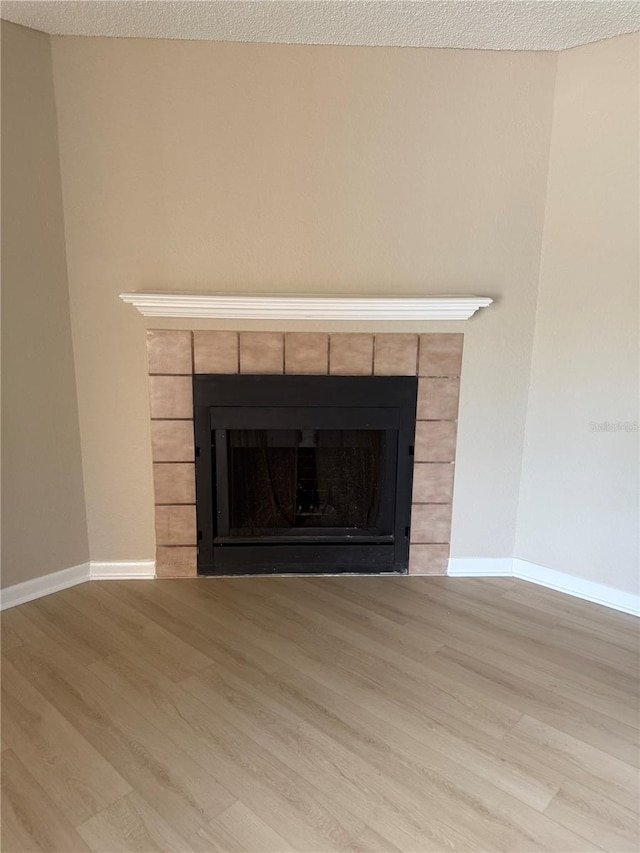 5635 Devonbriar Way Unit 103, Orlando, FL 32822 - room details with a tile fireplace, wood finished floors, and baseboards