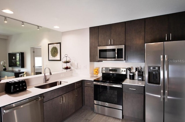 kitchen with light hardwood / wood-style flooring, appliances with stainless steel finishes, sink, and dark brown cabinets