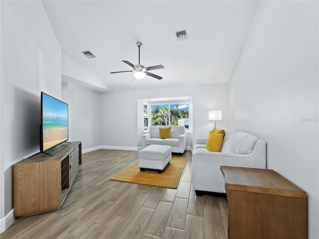 living room with vaulted ceiling, ceiling fan, and light hardwood / wood-style floors