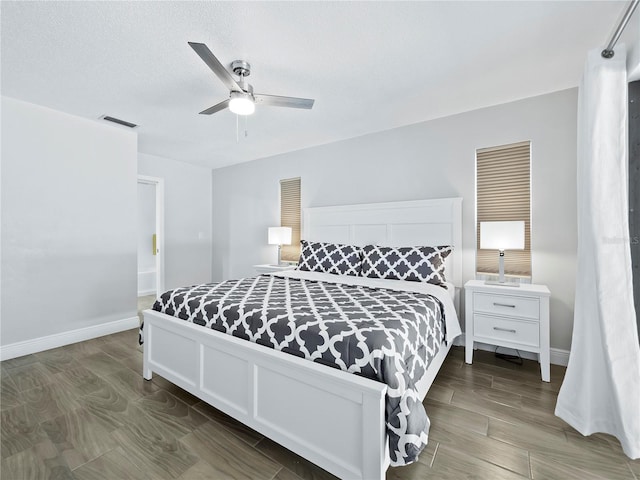 bedroom featuring a textured ceiling, dark wood-type flooring, and ceiling fan