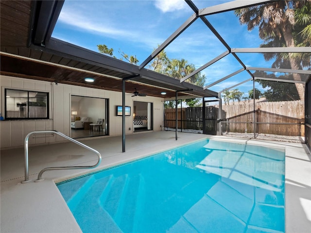 view of swimming pool featuring a patio, a lanai, and ceiling fan