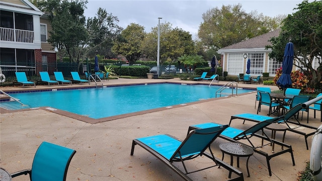 pool with fence and a patio