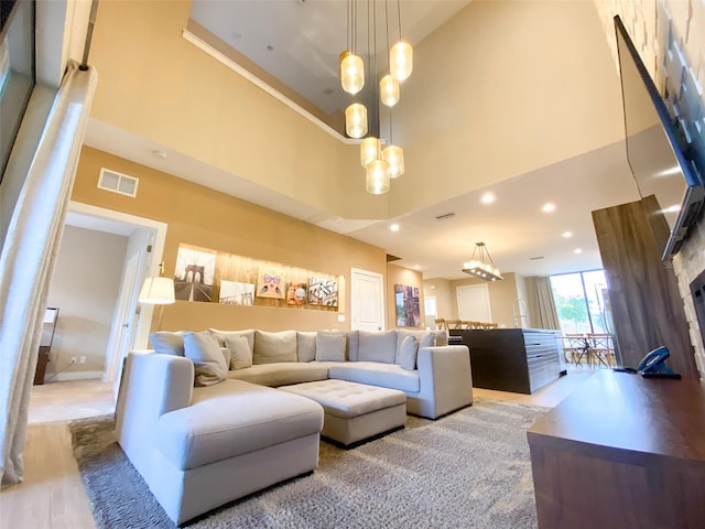 living room featuring a chandelier and a towering ceiling