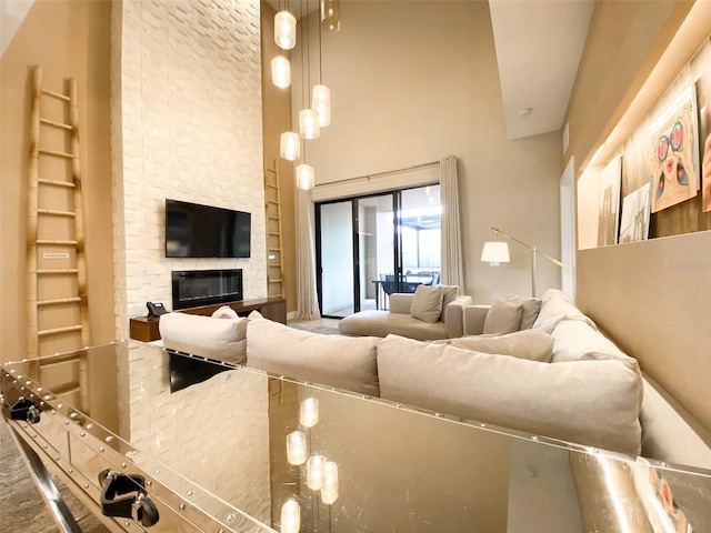 living room featuring high vaulted ceiling and a stone fireplace