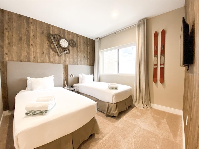 carpeted bedroom featuring wood walls