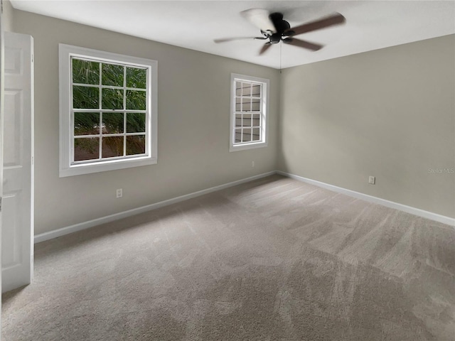 carpeted spare room featuring ceiling fan