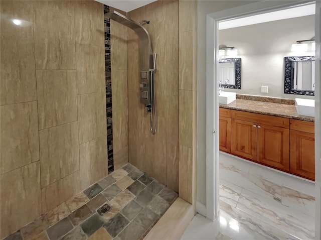 bathroom with dual bowl vanity, tiled shower, and tile flooring