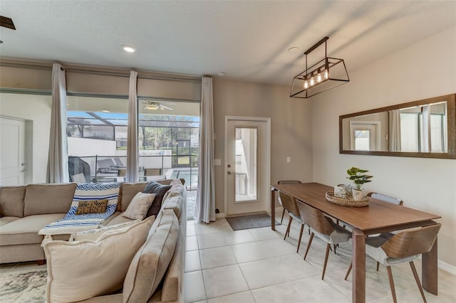 living room with light tile floors and ceiling fan with notable chandelier