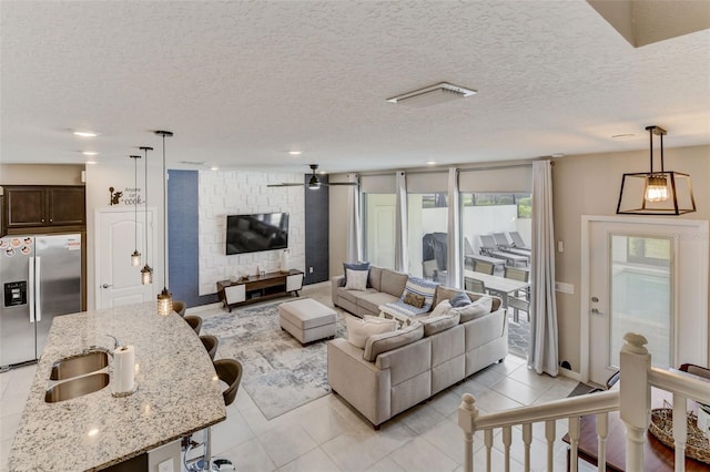 tiled living room with a textured ceiling and sink