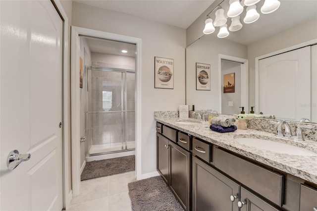 bathroom featuring an enclosed shower, oversized vanity, tile floors, and dual sinks