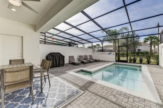 view of swimming pool with ceiling fan, a patio, and a lanai