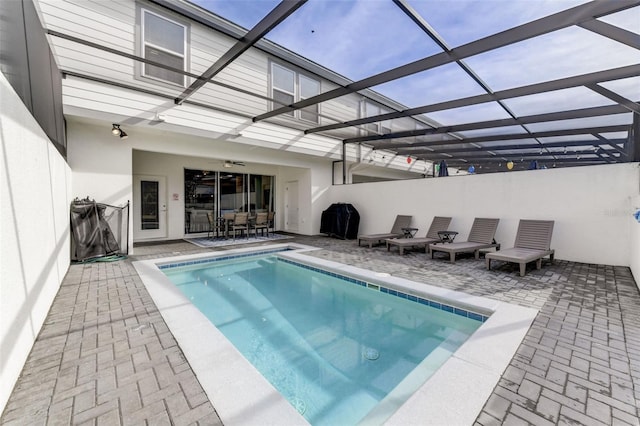 view of swimming pool featuring a patio and glass enclosure