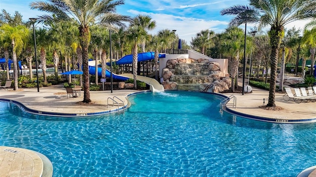 view of pool featuring a water slide and a patio