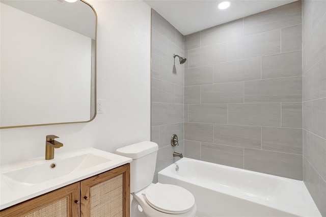 full bathroom with toilet, tiled shower / bath, and vanity