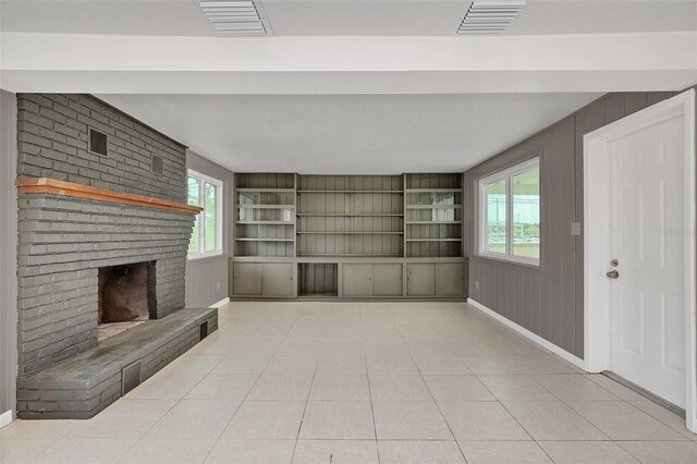 unfurnished living room featuring a fireplace and light tile patterned floors