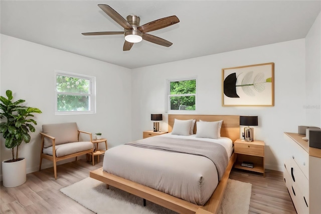 bedroom featuring multiple windows, light wood-type flooring, and ceiling fan