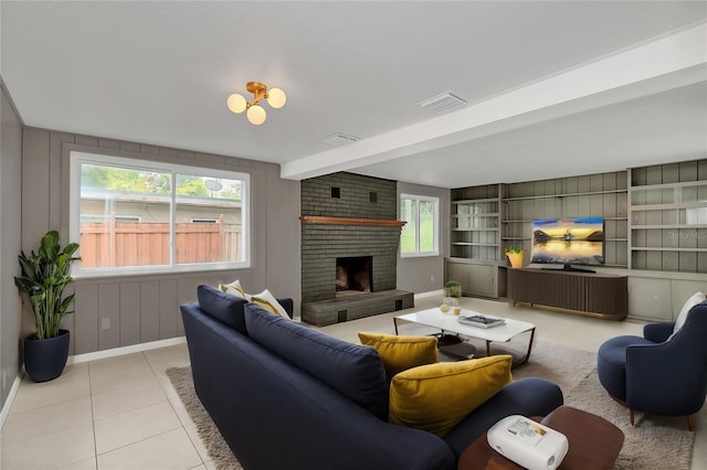 living room with brick wall, beam ceiling, light tile patterned floors, and a brick fireplace