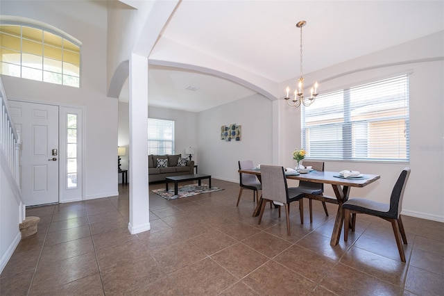 dining room with dark tile flooring and an inviting chandelier