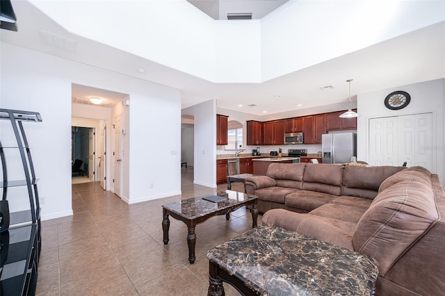 tiled living room featuring a high ceiling and sink