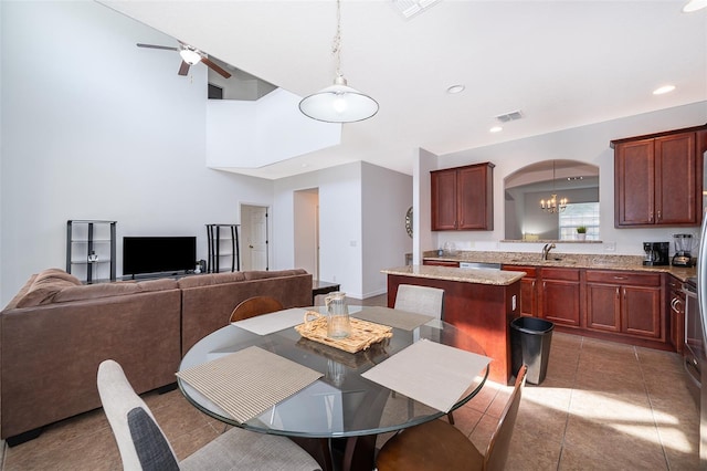 dining room featuring tile flooring, ceiling fan with notable chandelier, and sink