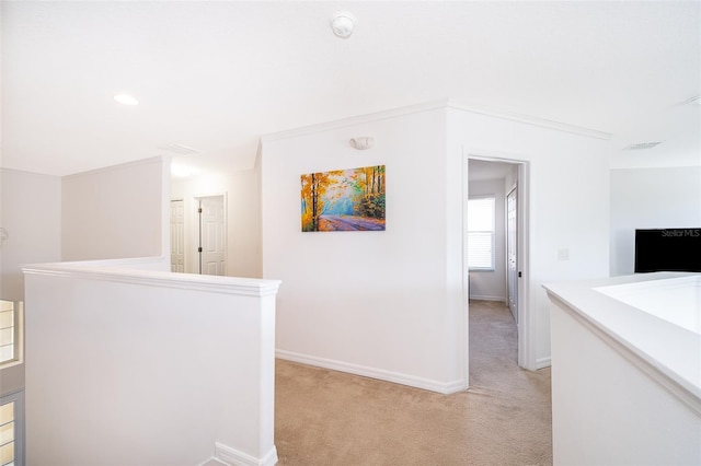 hall featuring light colored carpet and ornamental molding