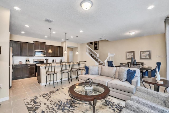 tiled living room featuring a textured ceiling