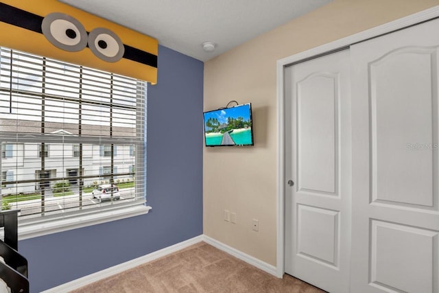 unfurnished bedroom with light carpet and a closet