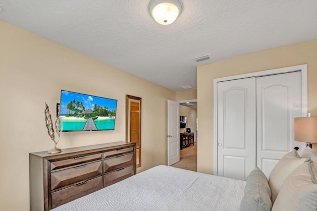 bedroom featuring carpet flooring, a textured ceiling, and a closet