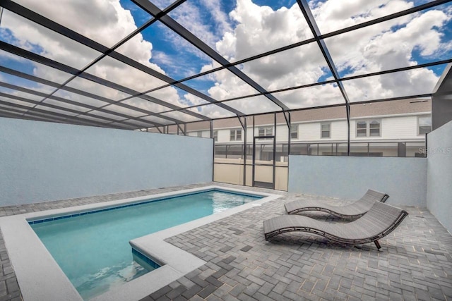 view of swimming pool featuring a lanai and a patio