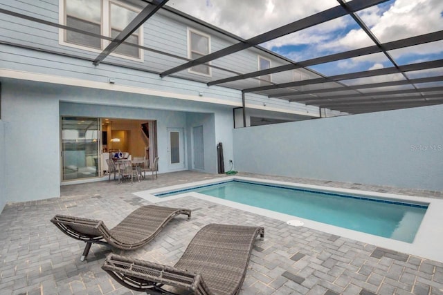 view of swimming pool featuring a patio and a lanai