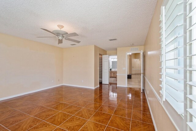 tiled spare room featuring ceiling fan and a textured ceiling