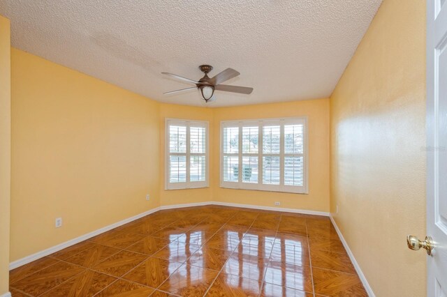 tiled spare room featuring ceiling fan and a textured ceiling