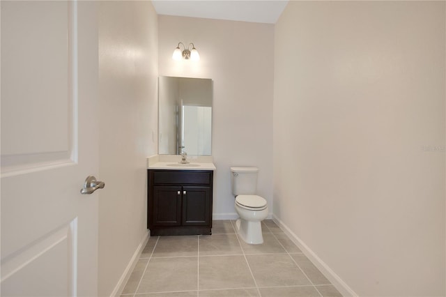 bathroom with toilet, tile floors, and vanity with extensive cabinet space