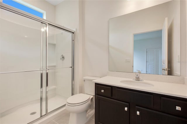 bathroom with vanity, tile floors, toilet, and walk in shower