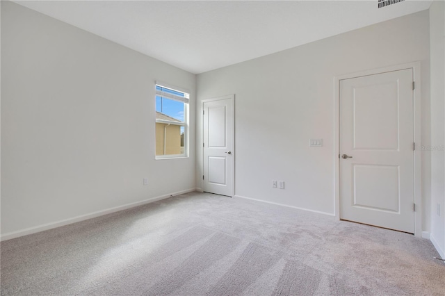 unfurnished room featuring light colored carpet