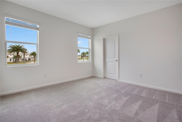 unfurnished room featuring light carpet