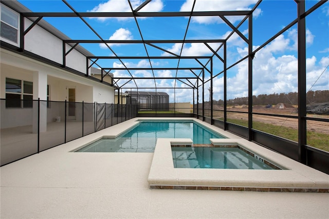 view of pool featuring a patio area, an in ground hot tub, and a lanai