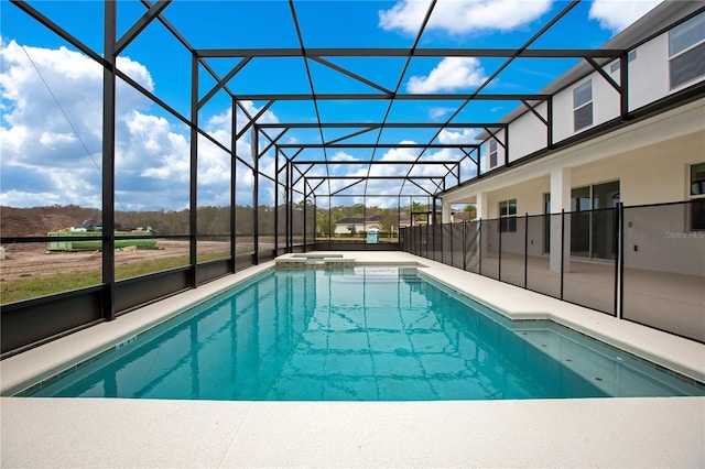 view of pool with glass enclosure and a patio area