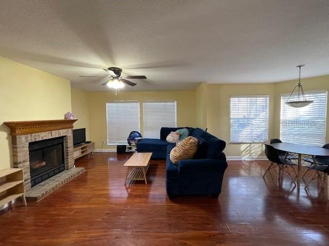 living room featuring a textured ceiling, ceiling fan, and dark hardwood / wood-style floors