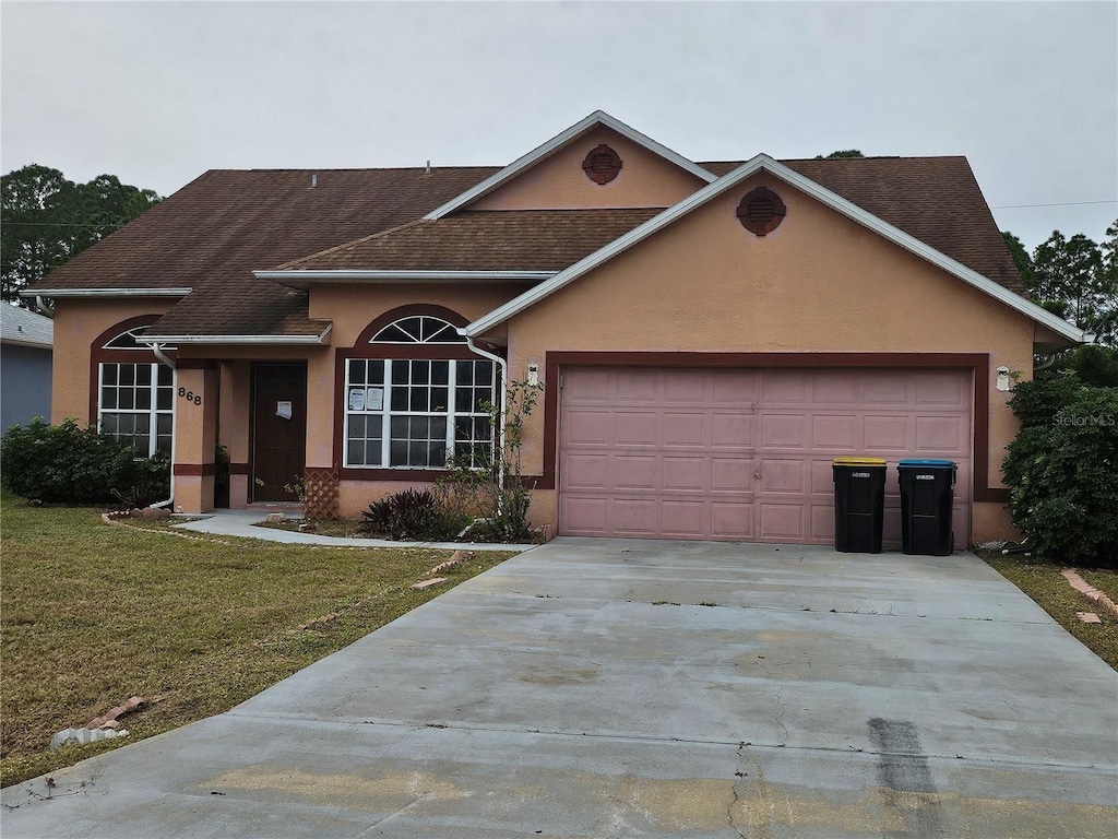 ranch-style home with a garage and a front yard