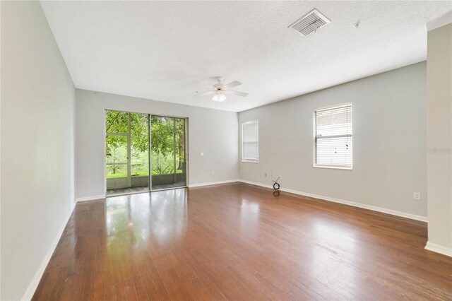 spare room with a textured ceiling, ceiling fan, and hardwood / wood-style floors